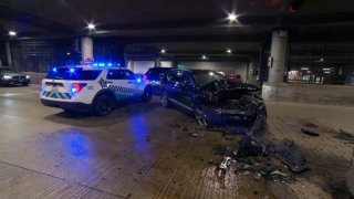 A Chicago police car is parked near a black SUV that hit a barrier and caught fire on Lower Wacker Drive Monday, June 9.